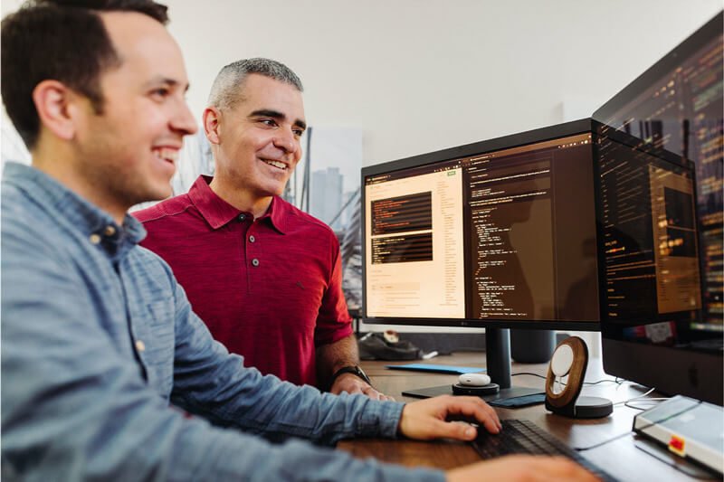 Brian Mariani with a programmer sitting in from of the computer